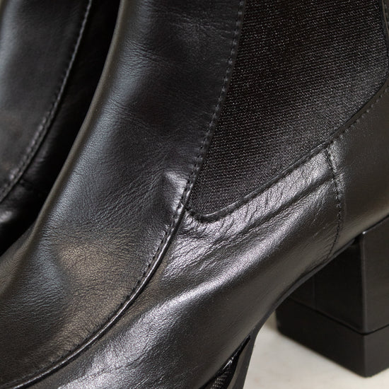 Close-up of black leather boots with a platform sole on a white background