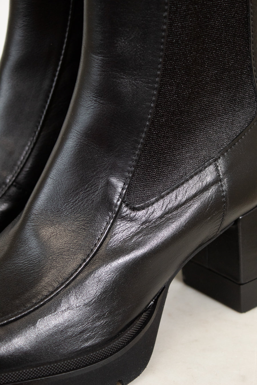 Close-up of black leather boots with a platform sole on a white background