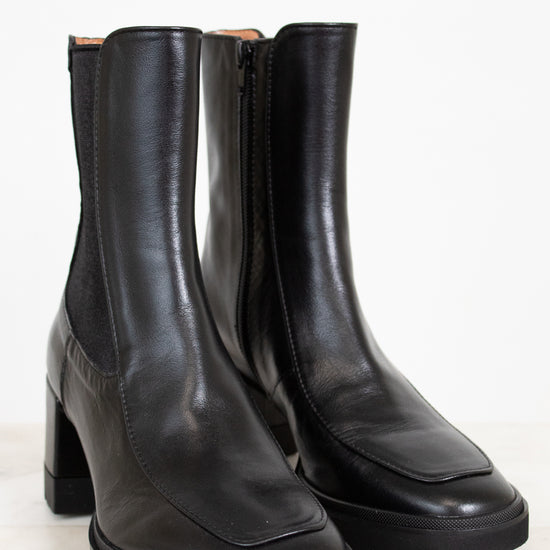 Pair of black leather boots on a white background