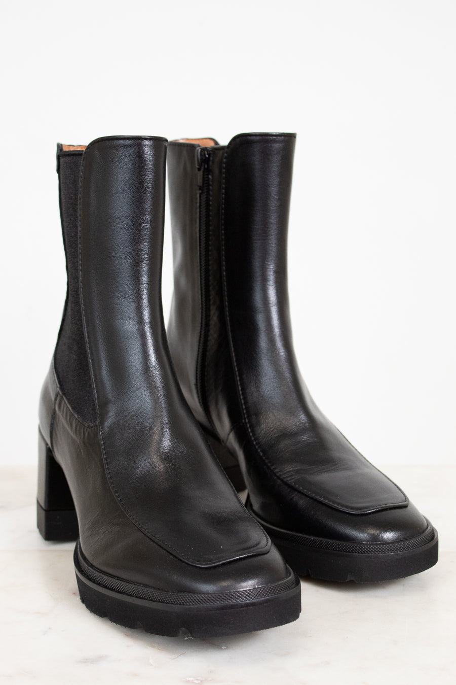 Pair of black leather boots on a white background