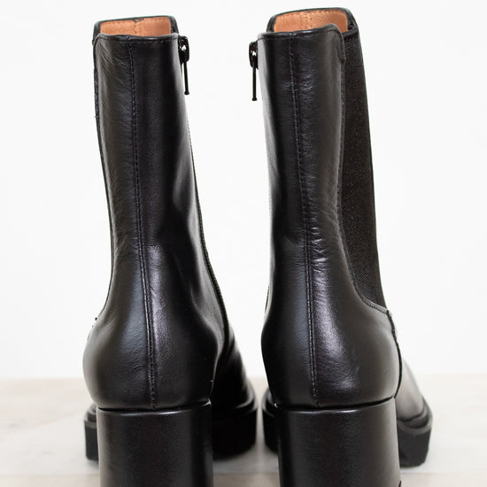 Pair of black leather boots on a white background
