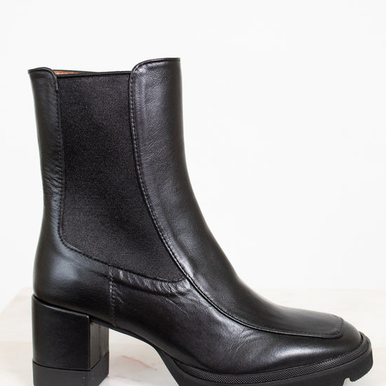 Black leather boots with a block heel on a white background