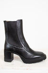 Black leather boots with a block heel on a white background
