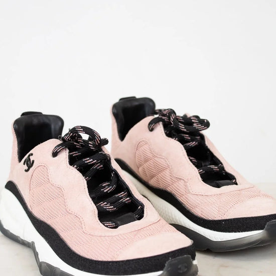 Pair of pink and black sneakers on a light gray background