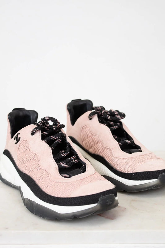 Pair of pink and black sneakers on a light gray background