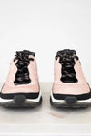 Pair of pink sneakers with black laces on a white background