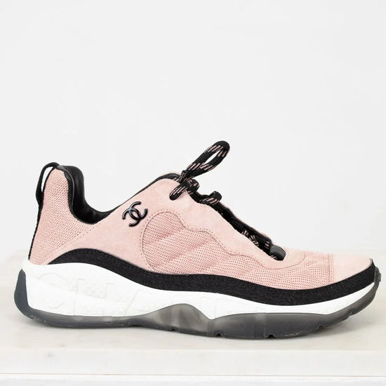 Pink sneaker with black accents on a white background
