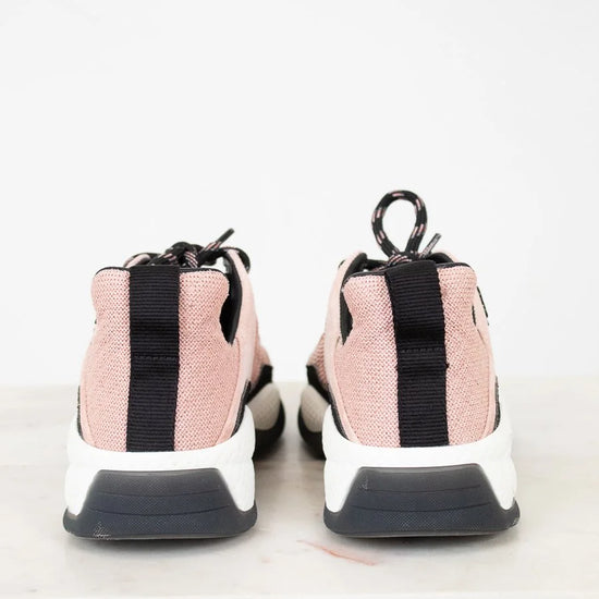 Pink sneakers with black accents on a light gray background