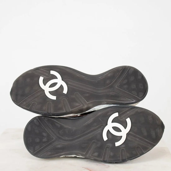 Black soles of shoes with white logo on a white background