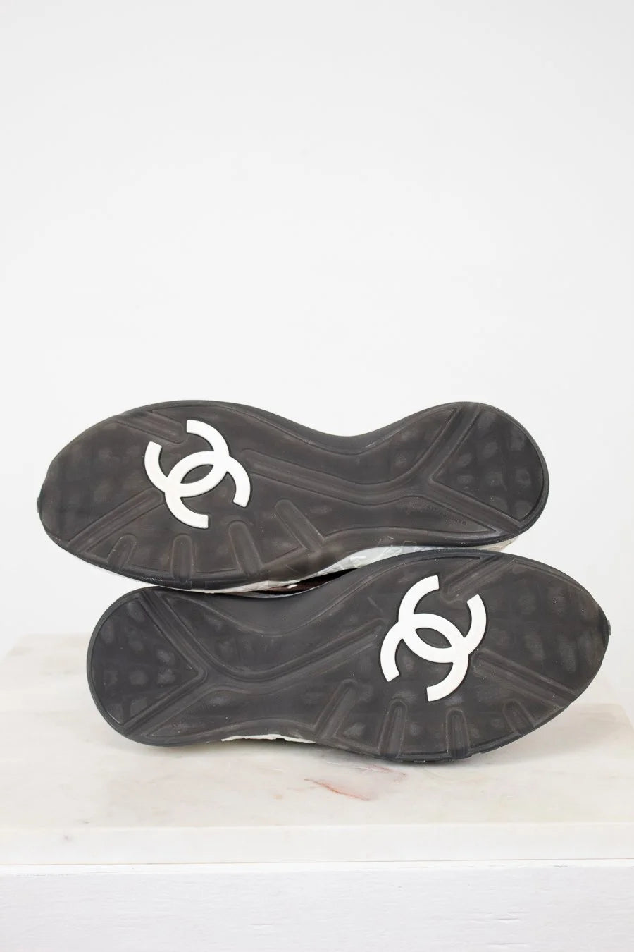 Black soles of shoes with white logo on a white background