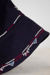 Navy blue fabric with embroidered patterns on a light gray background