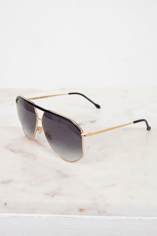 Aviator sunglasses with gold frame and dark lenses on a marble surface
