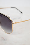 Gold-framed sunglasses with gradient lenses on a light gray background