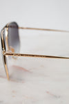 Gold-framed sunglasses with "Isabel  Marant" branding on a blurred background