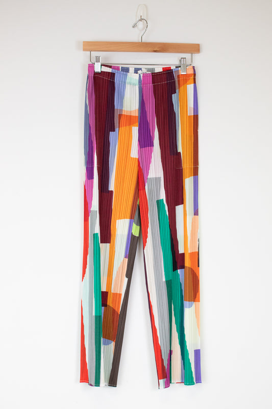 Colorful patterned pants on a hanger against a white background