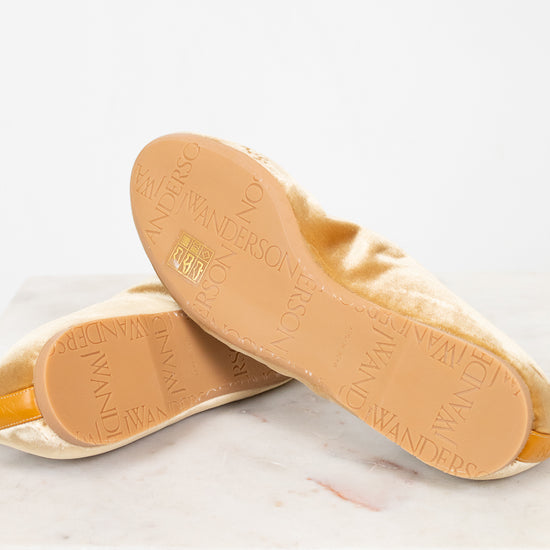 Close-up of tan soles with brand name on a light background