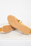 Close-up of tan soles with brand name on a light background