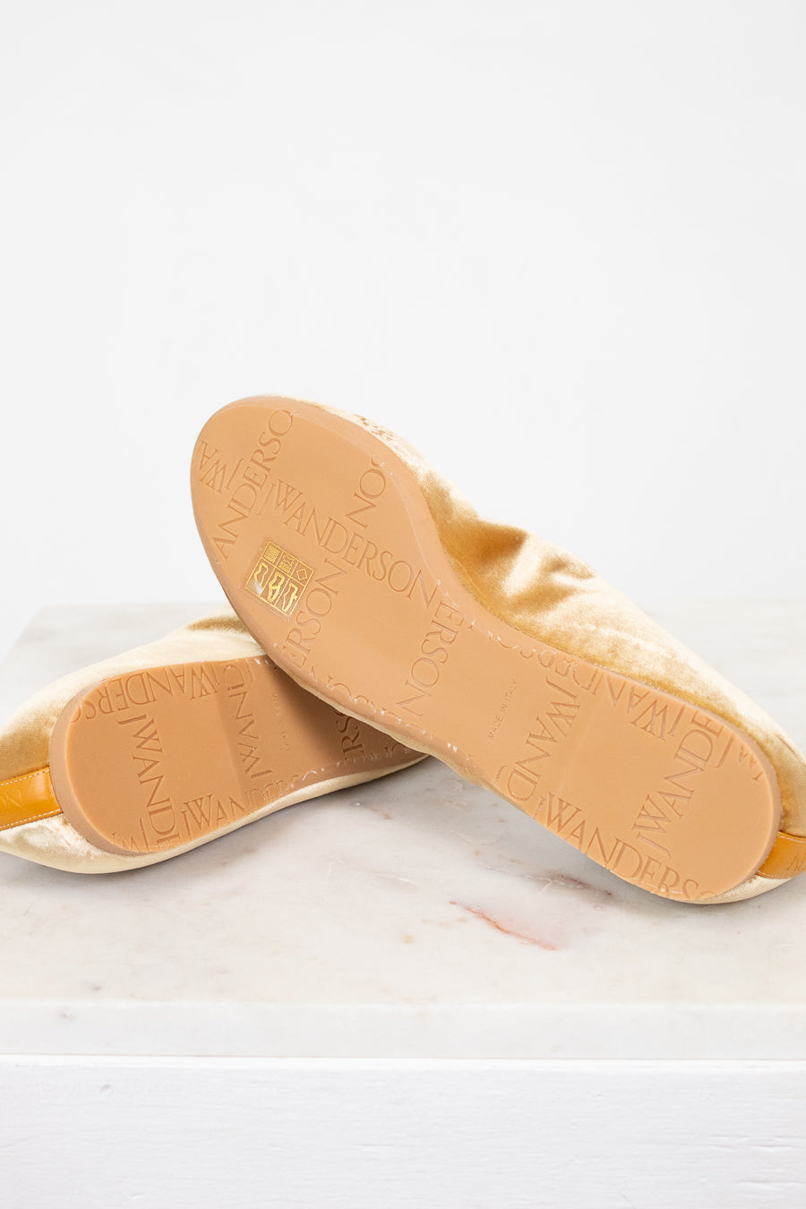 Close-up of tan soles with brand name on a light background