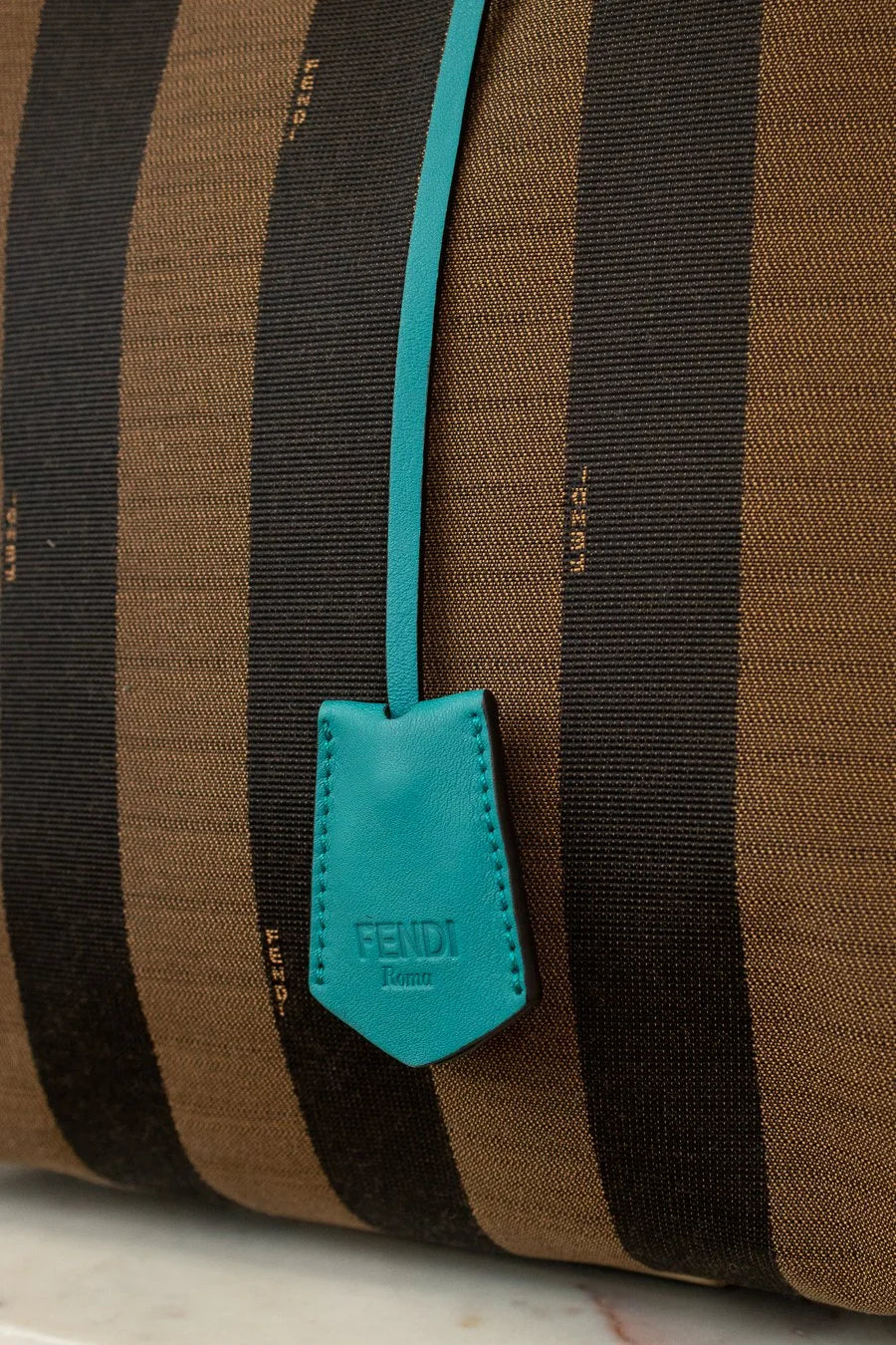 Brown and black striped bag with a turquoise Fendi tag.