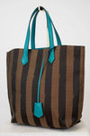 Striped tote bag with turquoise handles and accents on a white background