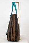 Striped handbag with turquoise handle on a white background