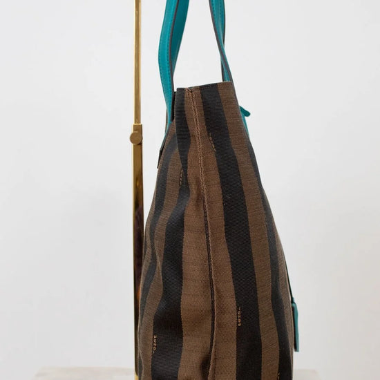 Striped handbag with teal handle on a white background