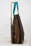 Striped handbag with teal handle on a white background