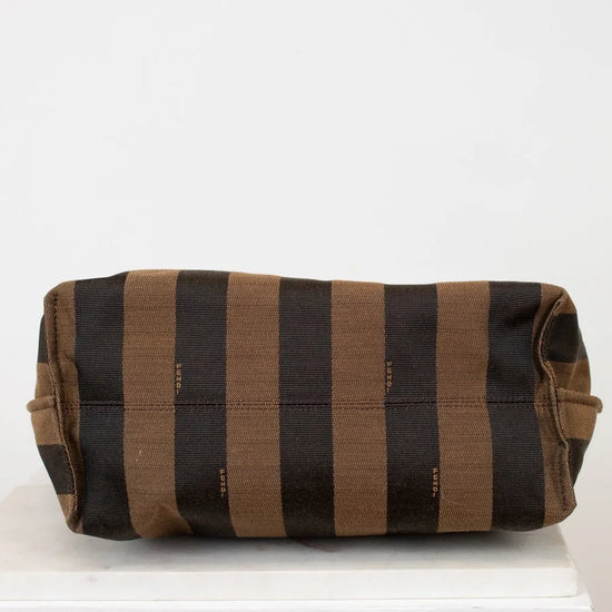 Striped fabric roll on a white surface with a light gray background