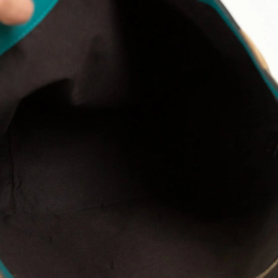 Close-up of a teal bag with a black interior