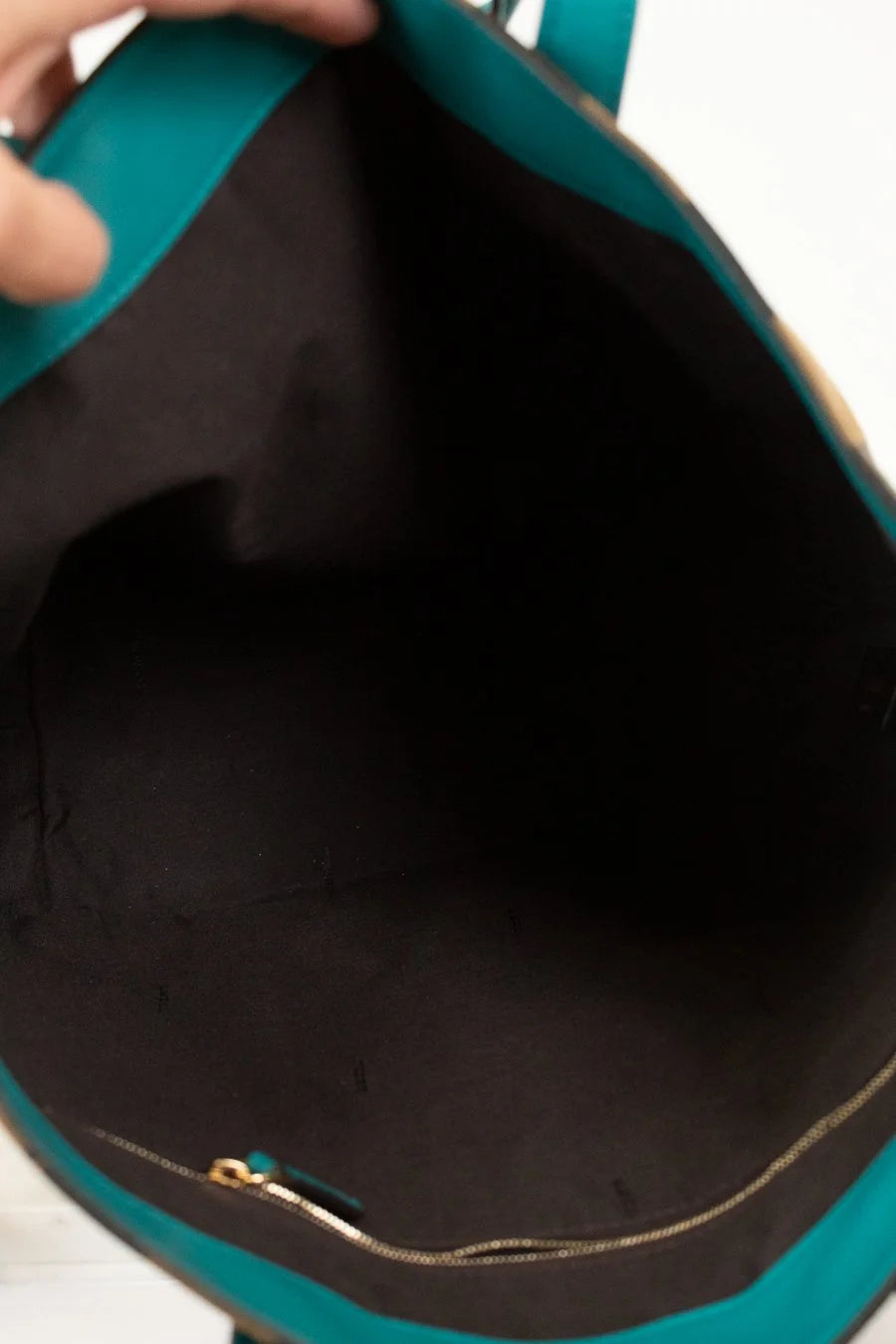 Close-up of a teal bag with a black interior