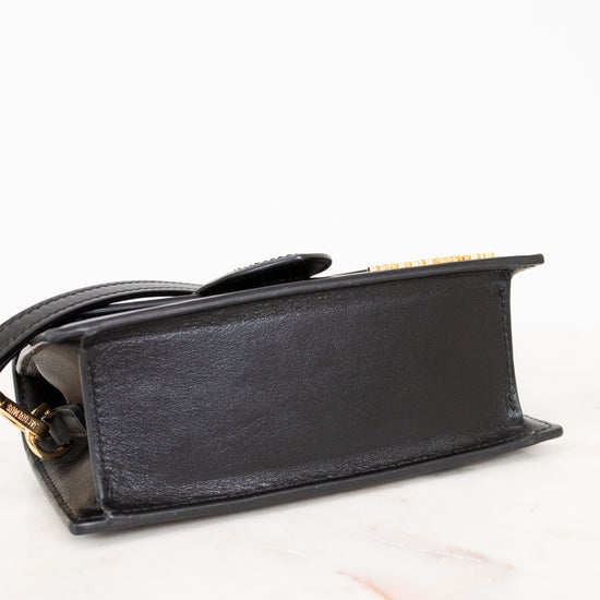 Black handbag with gold accents on a white background