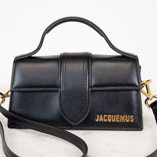Black handbag with gold accents on a white background