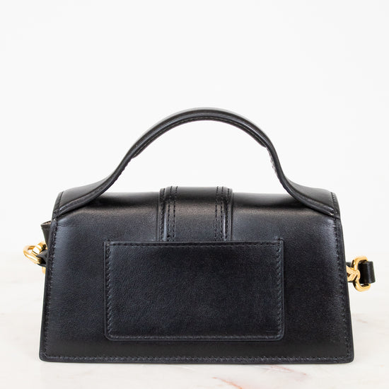 Black handbag with gold accents on a white background