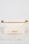 Cream-colored clutch with gold and silver accents on a marble surface