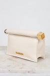 Cream-colored pouch with gold and silver accents on a marble surface