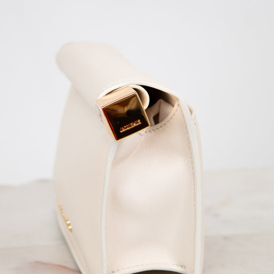 White side profile of clutch with gold  accent on a marble surface