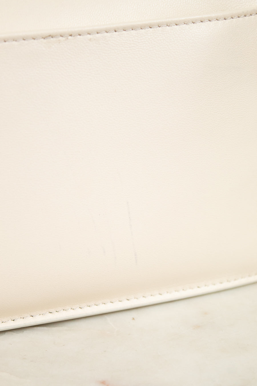 Close-up of a beige leather with a subtle mark on a light background