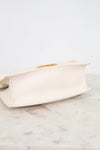 Beige clutch bag on a marble surface