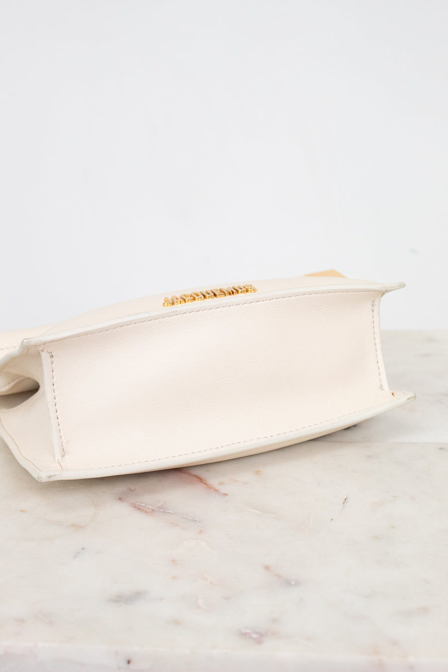 Beige clutch bag on a marble surface