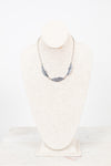 Feather necklace on a mannequin bust against a white background