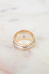 Silver and gold ring with brand logo on white background