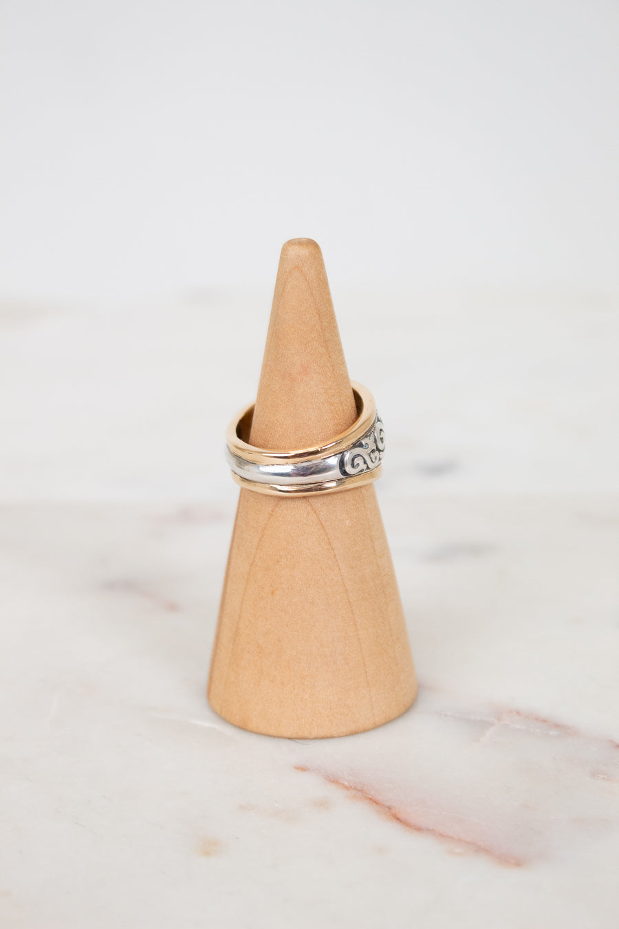 Ring on a wooden cone against a marble background