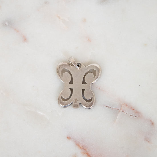 Silver butterfly pendant on a marble background