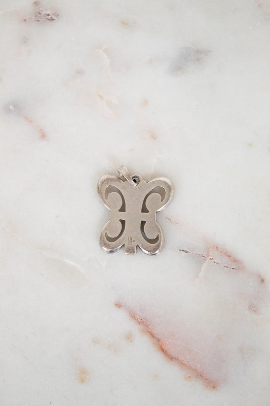 Silver butterfly pendant on a marble background