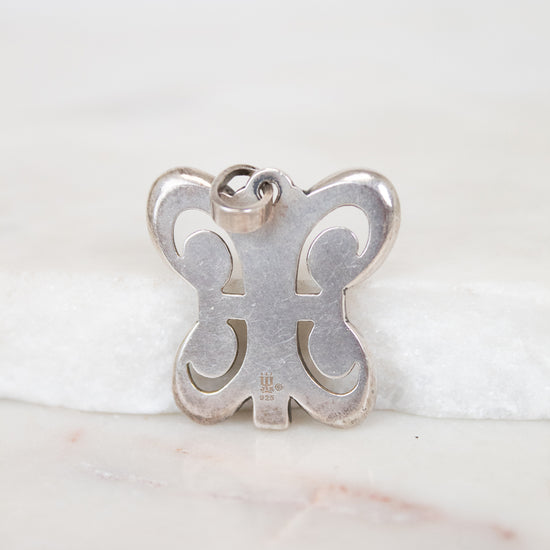 Silver butterfly-shaped pendant on a white background