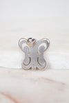 Silver butterfly-shaped pendant on a white background