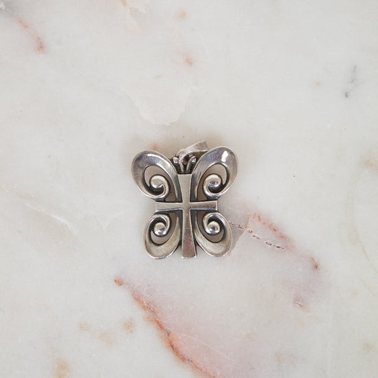 Silver butterfly-shaped object on a marble surface