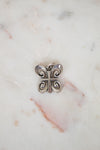 Silver butterfly-shaped object on a marble surface