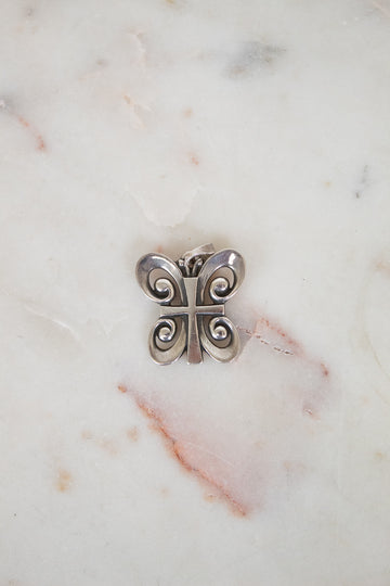 Silver butterfly-shaped object on a marble surface