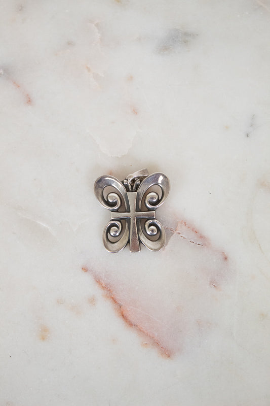 Silver butterfly-shaped object on a marble surface